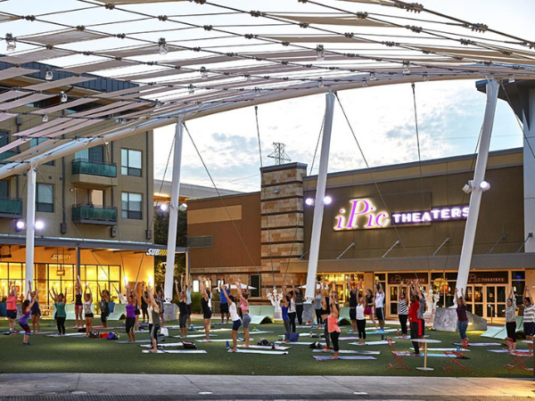 The Domain shopping center with a group of people practicing yoga outside