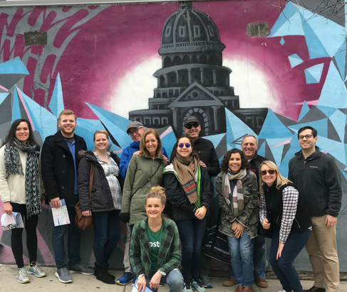 Group posing in front of a Texas State Capital mural